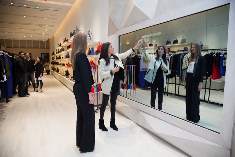Image of two woman standing in front of mirror in immersive retail store