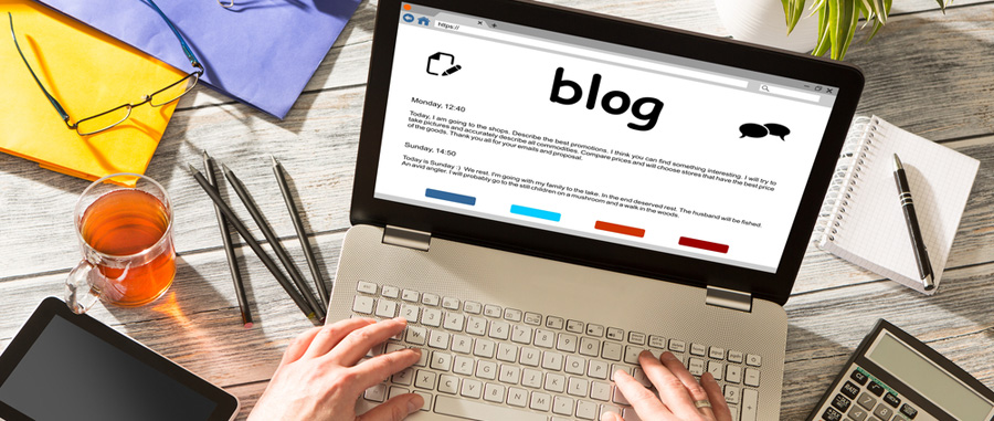 Image of laptop on a desk with the screen that reads blog