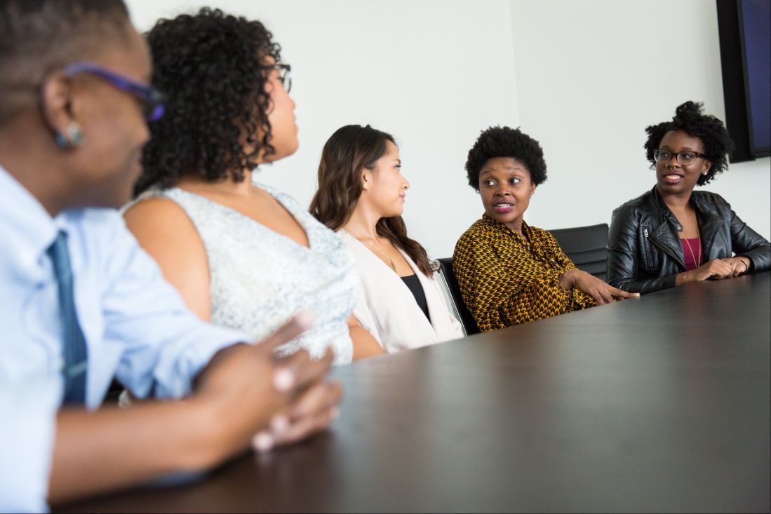 Educators sitting at a long table, talking with each other