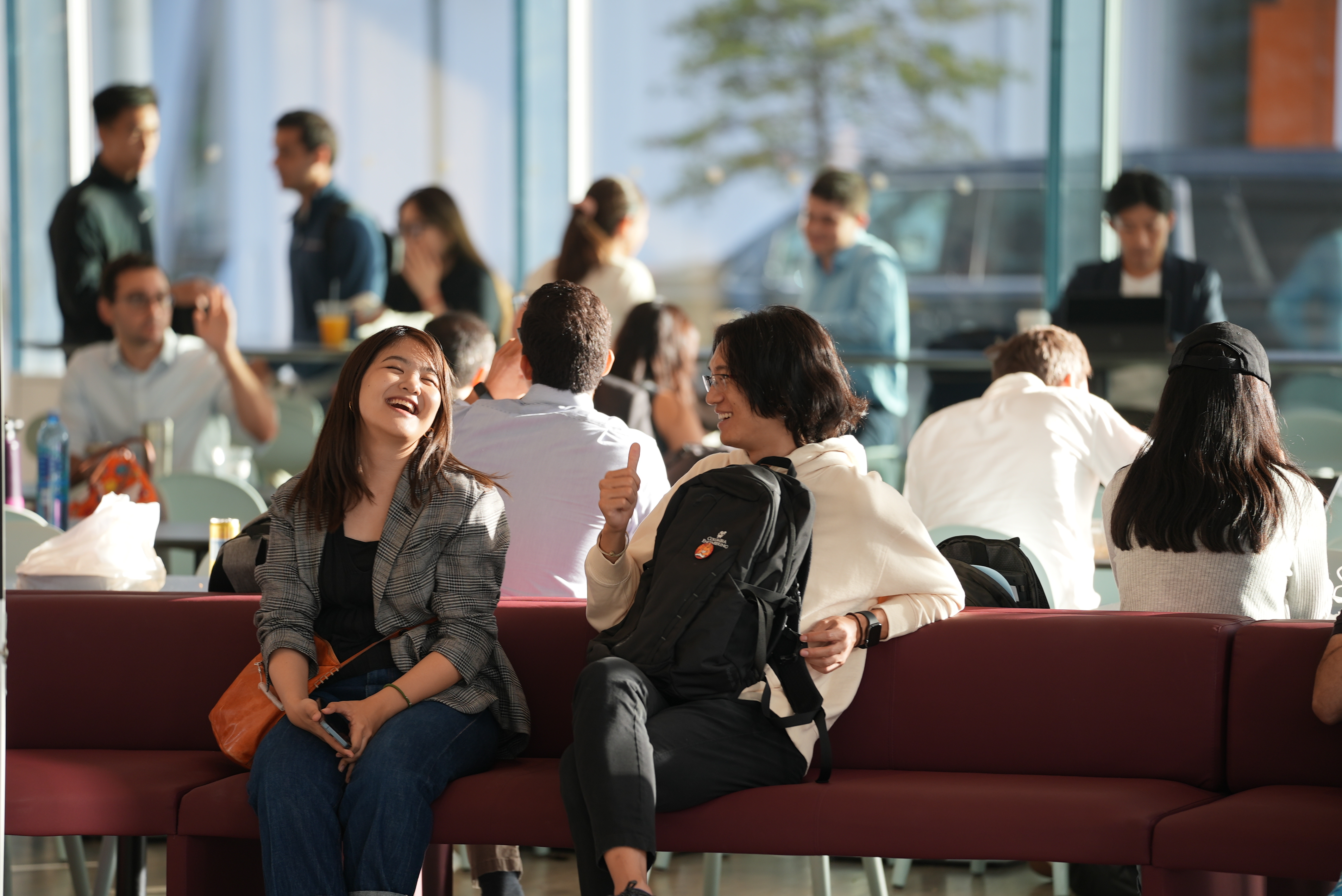 photo of two students laughing while sitting on bench in Geffen