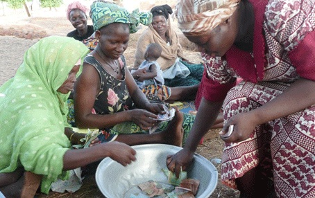 Three people sitting over a large mixing bowl