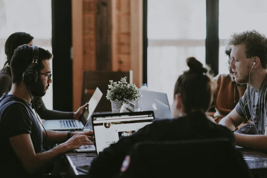 Employees in a meeting on laptops