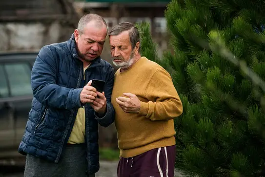 Two men discussing bad news, looking at the screen of a smartphone