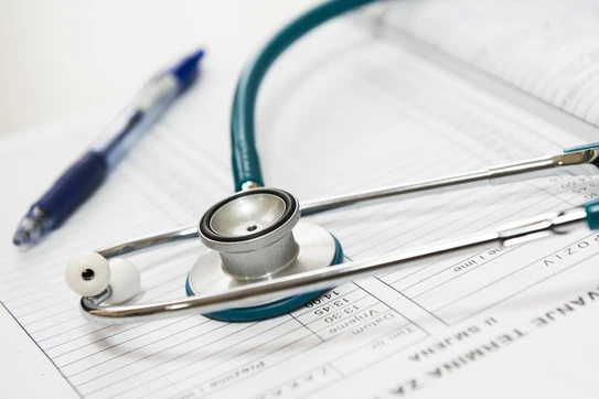 A stethoscope and a pen on an open book.