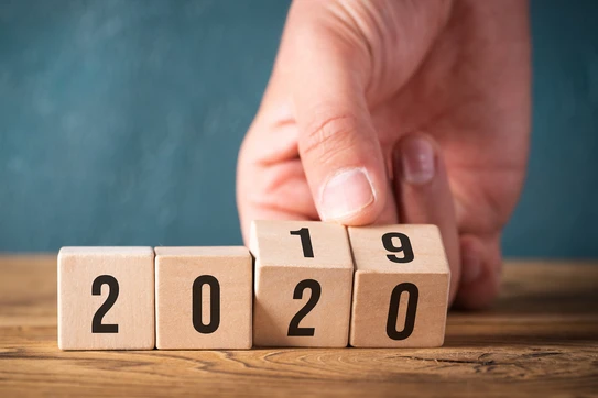 Wooden blocks and a hand flipping them from 2019 to 2020.