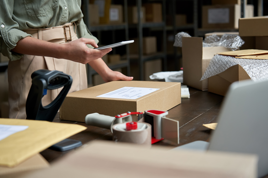 Person pointing a cellphone at a shipping label.