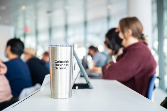CBS branded mug in a classroom