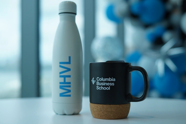 CBS-branded water bottle sitting on a table next to a CBS-branded mug