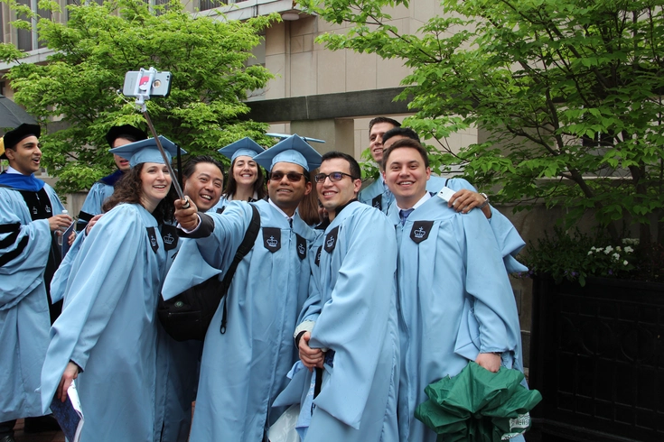 A group of graduating students pose for a selfie